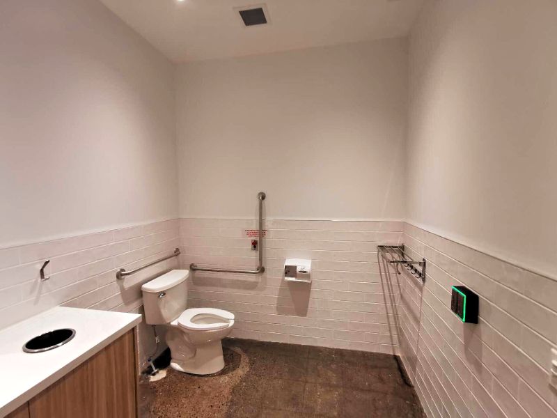 Accessible washroom with grab bars and a tile wainscot