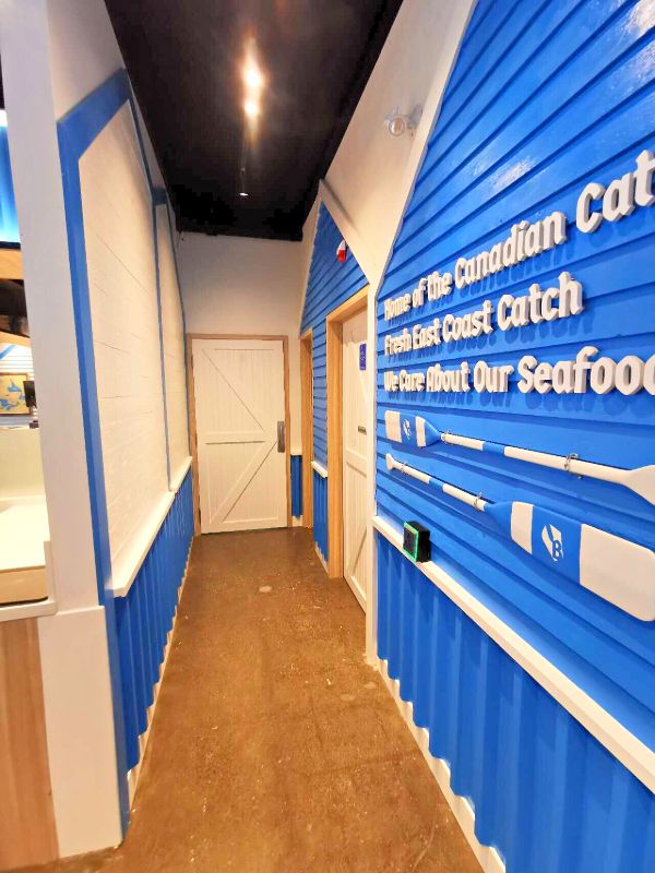 Hallway with blue siding, white barn doors and oars on the wall