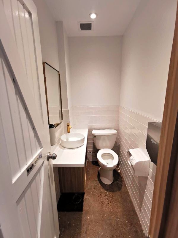 Small washroom with a vessel sink and brass-framed mirror