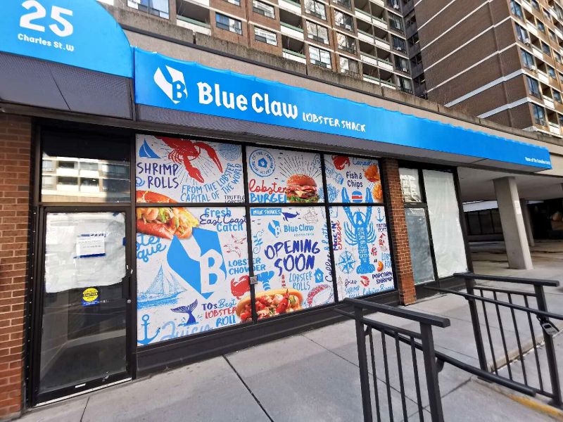 Blue Claw Lobster Shack storefront with a blue awning and opening-soon window graphics