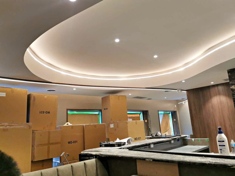 Curved bulkhead with an LED strip above the bar counter and booth seating